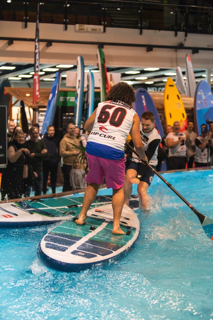 Indoor SUP boarders collide during the race.
